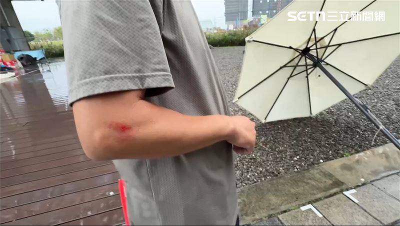 陽傘被瞬間大風吹倒，攤商慘遭拉倒摔傷。（圖／記者王紹宇攝影）
