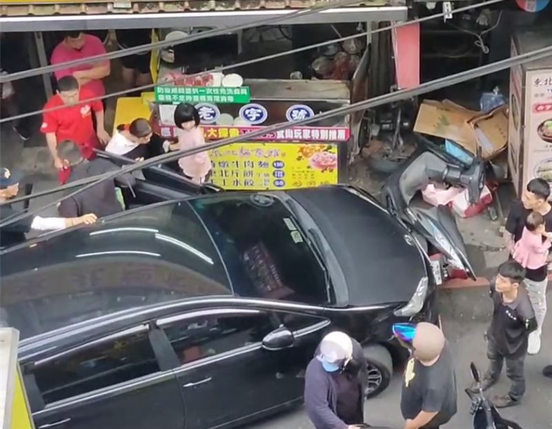黑色轎車衝撞基隆廟口夜市外的兩家店家。（圖／翻攝畫面）