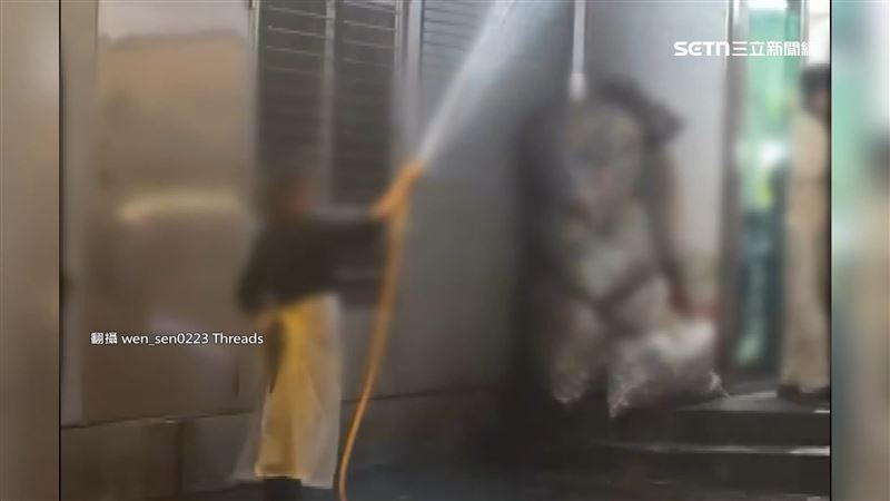 台北信義區「酒吧一條街」5日凌晨，夜班清潔阿姨拿水管往天空灑水，疑似在驅趕酒客