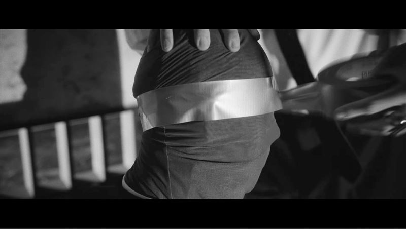 T.O.P露出猙獰表情將蒙面人的眼部用膠帶綑綁。（圖／翻攝自YouTube@Studio54 MV畫面）