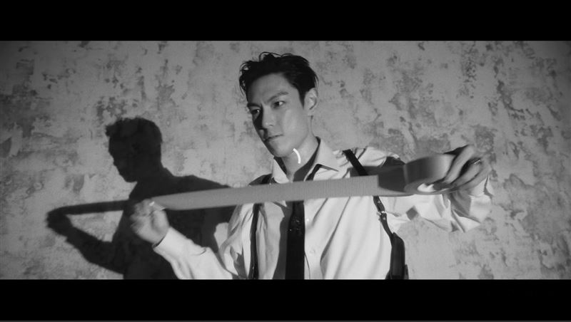 T.O.P露出猙獰表情將蒙面人的眼部用膠帶綑綁。（圖／翻攝自YouTube@Studio54 MV畫面）