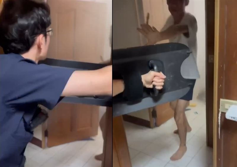 員警往房門狂踹4腳，最後男子主動將房門打開，手上疑持有利刃。（圖／翻攝畫面）