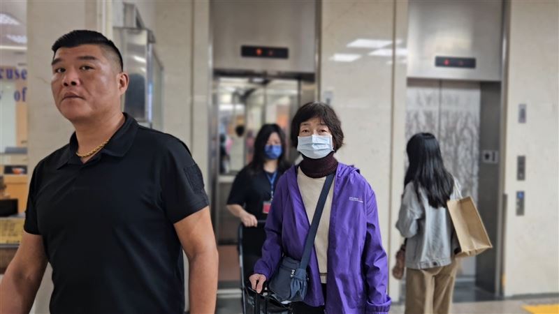 1111人力銀行創辦人林文雄派保鑣，護著妹妹林麗貞（後）出庭。（圖／翻攝畫面）