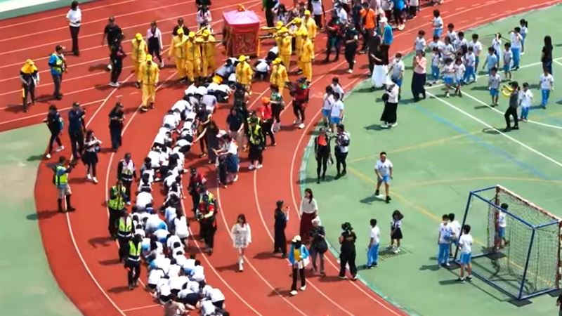 白沙屯媽祖進入大甲文昌國小，讓師生們排隊鑽轎腳祈福。（圖／翻攝自YT白沙屯媽祖網路電視台）