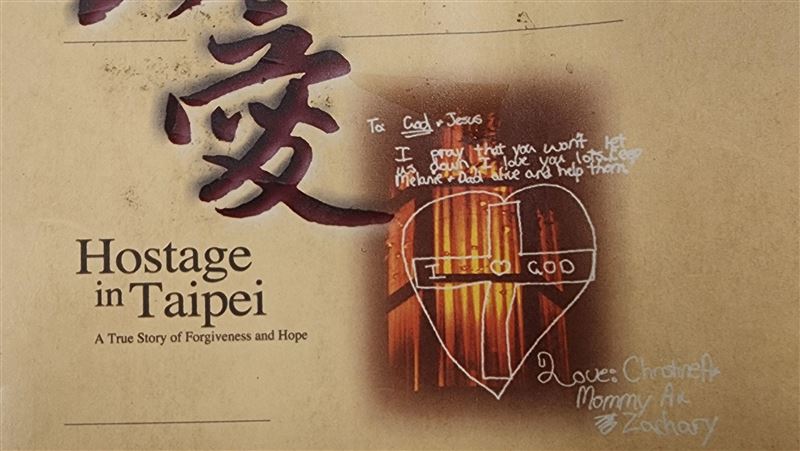 陳進興挾持南非武官,當年12歲卓懋祺小女兒克麗絲汀被挾持時靈機一動畫一幅畫十字架畫,觸動殺人魔陳進興良心,最終投降。(圖/翻攝自《真愛 南非武官與陳進興的故事》)