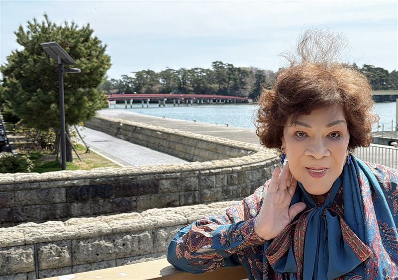 周遊身後紅色的長橋「福浦橋」是台灣人捐贈兩億元興建的。(圖/李朝永提供)