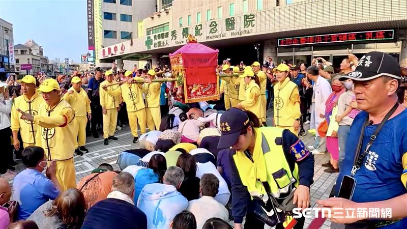 白沙屯媽祖不僅特地「急轉彎」到秀傳醫院,還讓現場的民眾鑽轎腳。看見鑾轎緩緩抬高,原本守候在旁的醫護人員、穿著住院服的患者,以及神色憔悴的家屬,紛紛放下心中的矜持與重擔,一個接一個虔誠地跪伏在地,當「粉紅超跑」從頭頂輕輕掠過的瞬間,現場許多人忍不住淚流滿面。(圖/秀傳醫院授權提供)