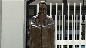 捐贈者總務主任江明翰與孔子像合影（圖／國立臺南護專提供） 