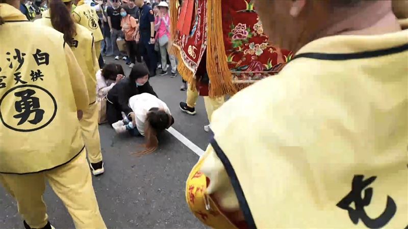 姑姪2人與男童阿嬤在轎班人員指引下跪地鑽轎腳。（圖／翻攝畫面）