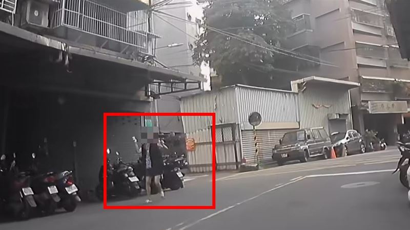 婦人雙手拿刀在板橋街頭揮舞。（圖／翻攝自臉書我是板橋人）