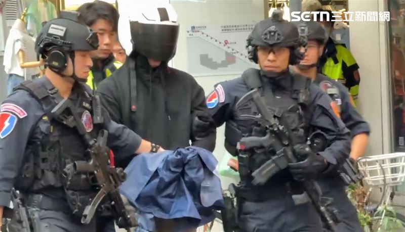 北市中信銀行驚傳搶案，林姓男子持假槍遭逮，霹靂小組全副武裝警戒移送。（圖／翻攝畫面）