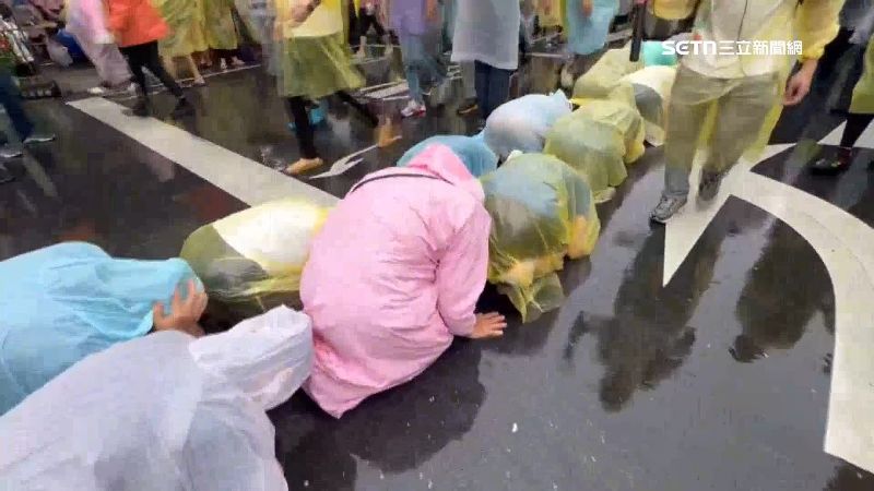 就算不間斷地下著雨民眾還是要跪地鑽轎底