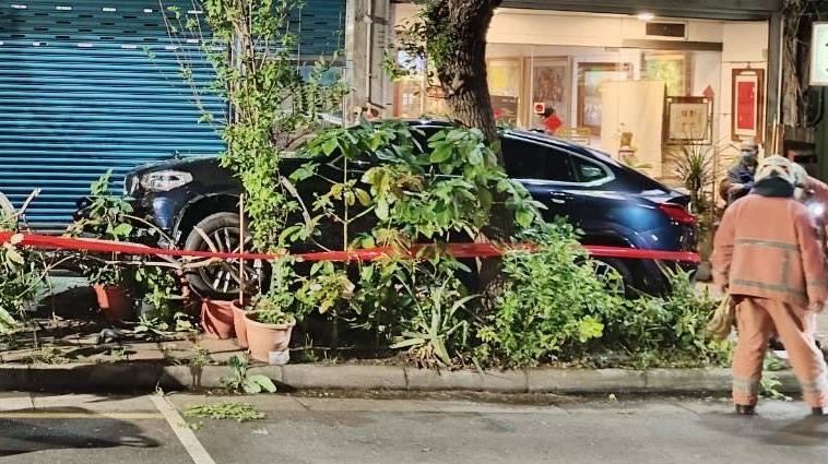 BMW休旅車因不明原因暴衝上人行道撞斷路樹。（圖／翻攝畫面）