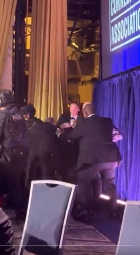 川普倉皇逃生「踉蹌失足」，被隨行人員扶起躲到後台。（圖／翻攝自X平台 @TMZ）