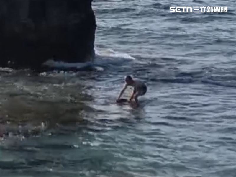 海龜痛苦掙扎，一個湧浪襲來，男子重心不穩，手才鬆開。（圖／翻攝畫面）
