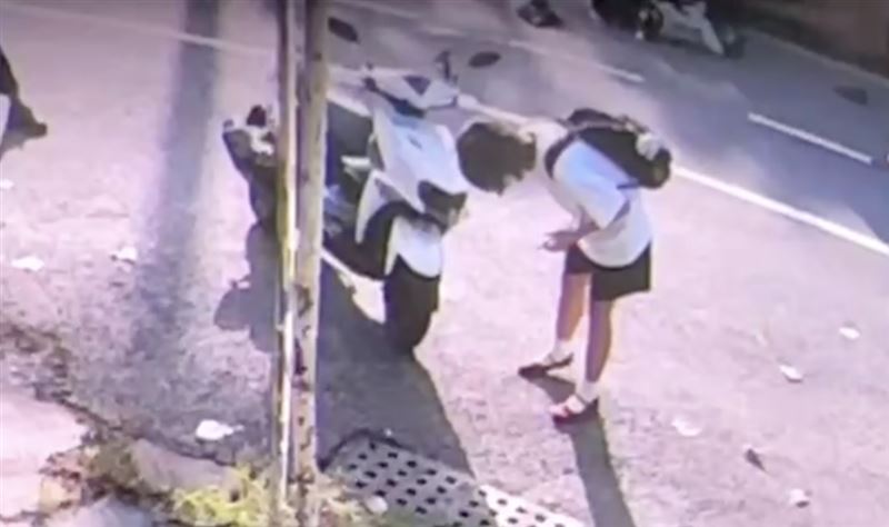 女大生肇事後頻頻查看自己的機車車損，從未上前關心查看女警狀況。（圖／翻攝畫面）