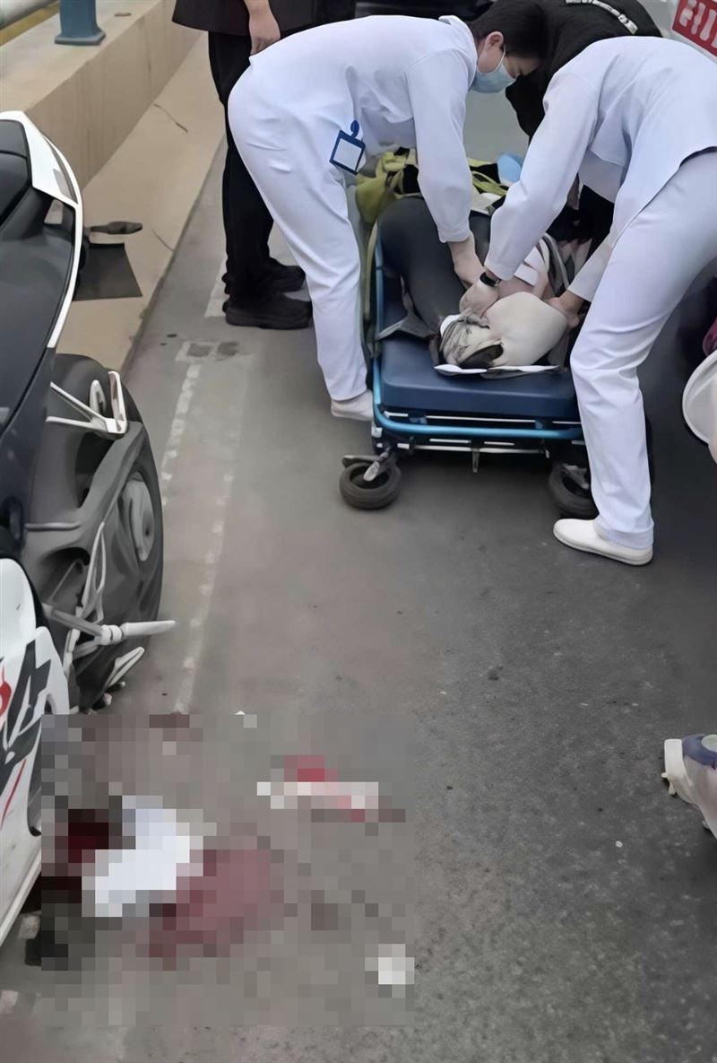 醫護人員到場抬走女騎士，地上還有血跡。（圖／翻攝自微博）