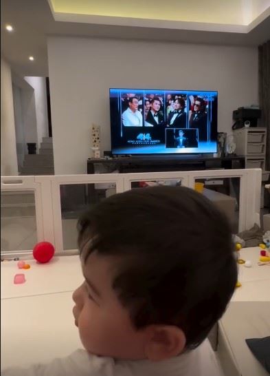 梁家輝本月4月19日於第44屆香港電影金像獎，外孫也在電視前看外公得獎。（圖／翻攝自梁靜曦IG限時限動）