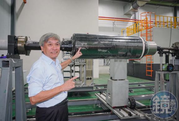 翁冠群指著自行研發的大型纏繞機解說：「纏繞機屬國際出口管制，買不到，我們就自己做。」剛花一星期纏繞完碳纖維的火箭燃料槽就是一顆大型高壓氣瓶。（圖／鏡週刊）