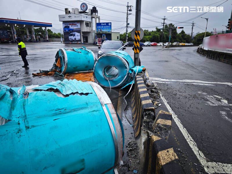 新北莊男駕駛的曳引車掉落3個大型鐵桶。（圖／翻攝畫面）