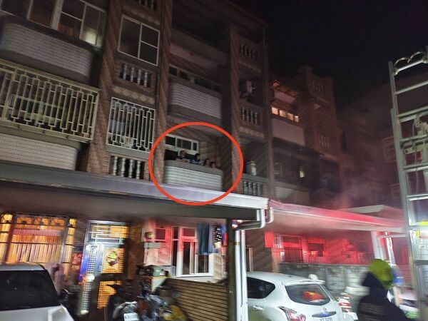 透天厝的1樓客廳起火，屋內民眾受困在2、3樓陽台。（圖／翻攝畫面）