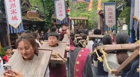 中國一處風景區讓遊客體驗戴罪枷坐囚車遊街，引發討論。（翻攝微博）