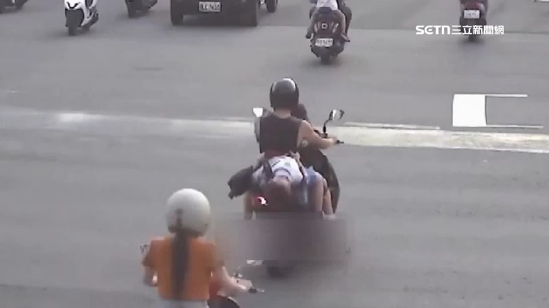 家長騎機車載小朋友，後座小朋友上半身整個躺在機車上睡覺