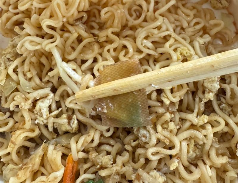 網友在樂天球場點了炒泡麵，發現食物裡有「OK繃」，而且上面還沾著綠色藥膏。（圖／翻攝Threads@hungyulin_n）