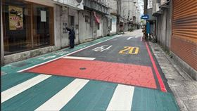 新北市新店區中正路117巷設置「行人優先區」，除新增速限20公里標誌，更首度導入彩色壓花瀝青鋪面。（圖／新北交通局提供）