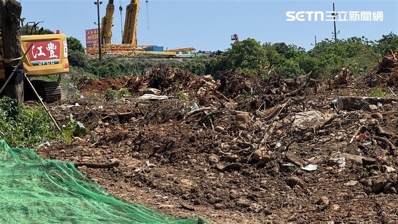 台中市捷運藍線龍井機廠用地2024年會勘舊發現大量廢棄物，至今預定地範圍內仍可見混雜各種垃圾的黑色廢土堆得比路面還高。（圖／記者王乙徹攝影）