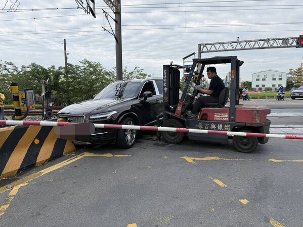 救援人員出動推高機將休旅車「鏟走」，恢復鐵路通行。（圖／翻攝畫面）