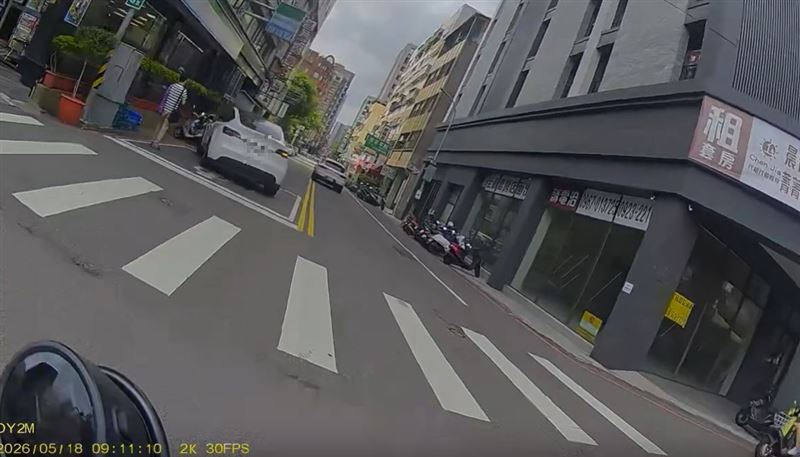 特斯拉女駕駛疑似恍神，右轉時失控暴衝連撞路邊9輛機車，一名路人差點遭受波及。（圖／翻攝自Threads @sinai228）