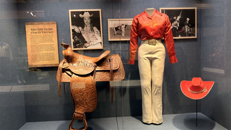 Gene Autry Rodeo雕花馬鞍與紅色女牛仔服裝同場展出，搭配「From Ranch &amp; Parade Girls To Barrel Racers」歷史介紹，呈現女性牛仔從表演走向職業桶賽競技的演變歷程。（圖／記者蕭翰弦攝影）
