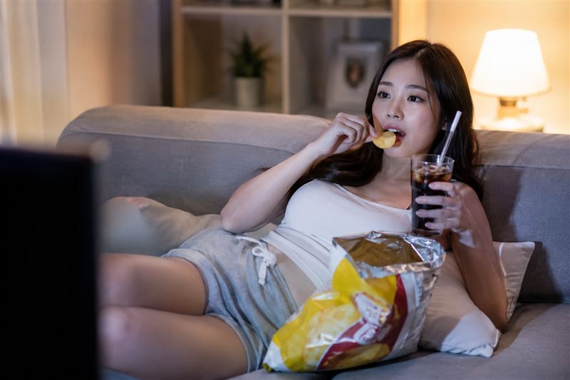 心臟外科醫生示警，許多人習慣一邊追劇、一邊吃薯片配可樂，看似放鬆療癒，其實卻可能悄悄傷害健康。（示意圖／AI生成）