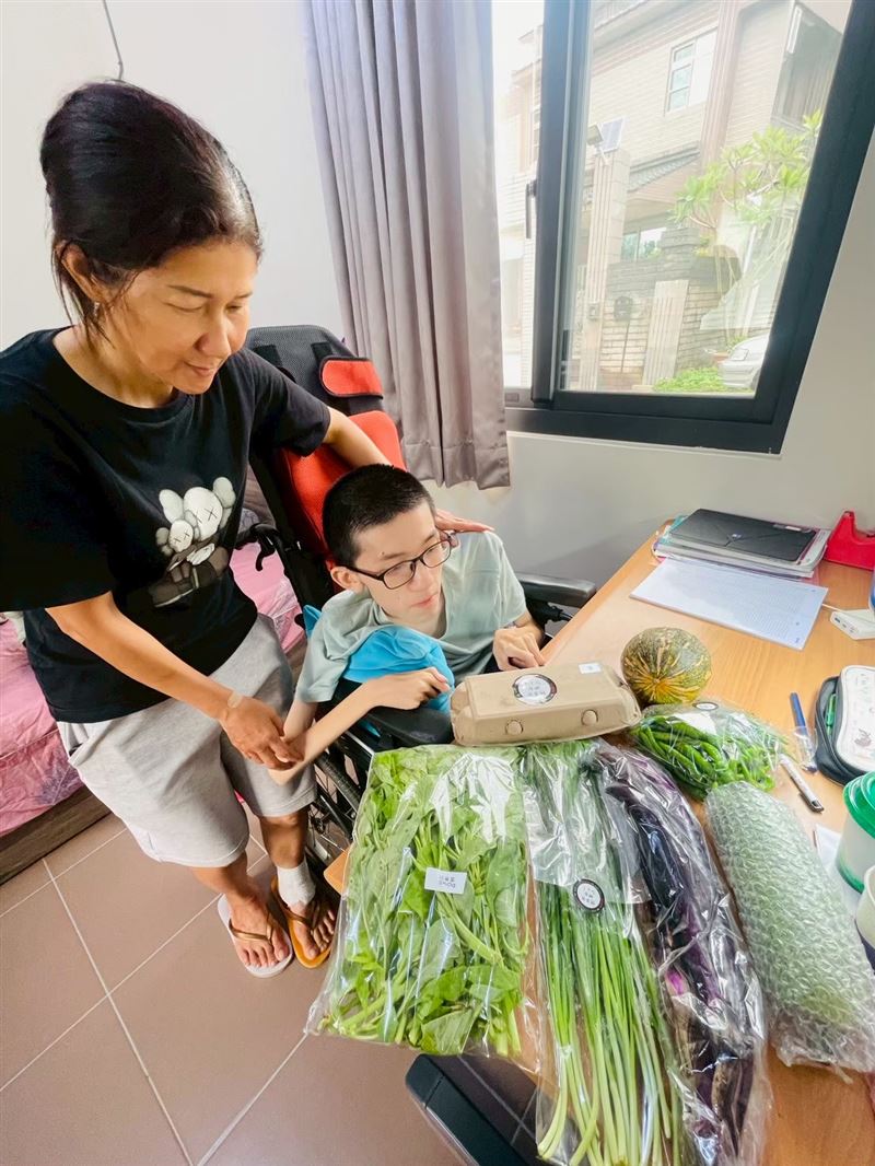 健安和媽媽接收展望會發放的蔬菜箱感謝大家的善心。（圖／台灣世界展望會提供）