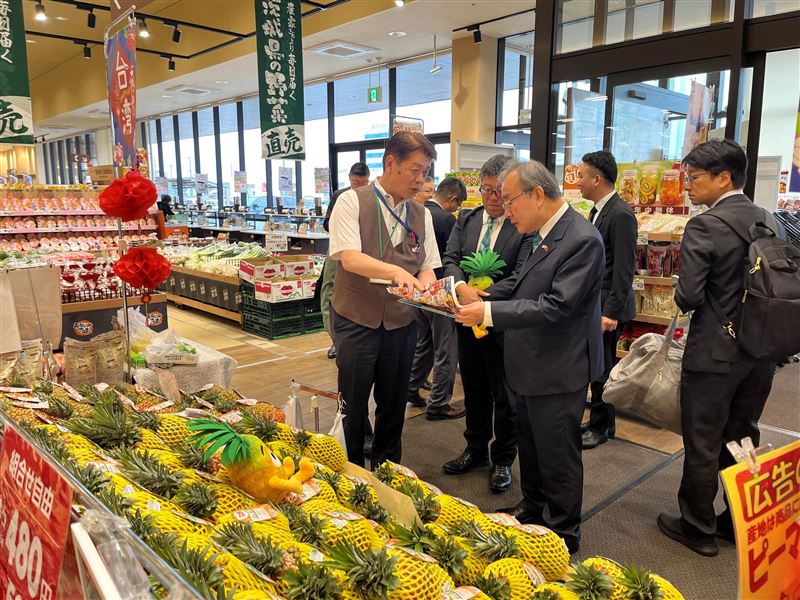 超市水戶元吉店中田厚志店長(左)在訪視臺灣鳳梨銷售時,向農業部胡忠一次長(右)介紹芒果鳳梨行銷策略。(圖/農業部提供)