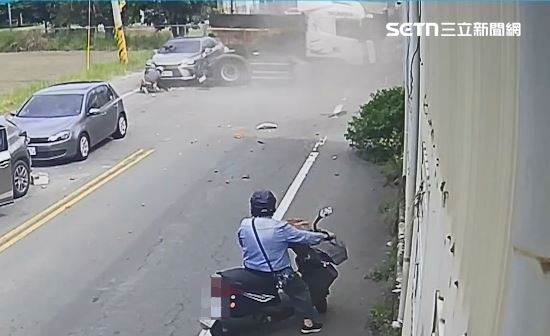 砂石車車輪撞擊機車車身，後座女乘客當場彈飛在地。（圖／翻攝畫面）