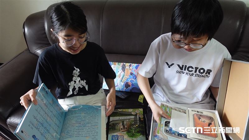 羽桂拿出自己小時候和國小、國中和高中的畢業紀念冊分享給好友文陽看，她坦言，自己確實沒有很喜歡拍照。（圖／記者張雅筑攝）
