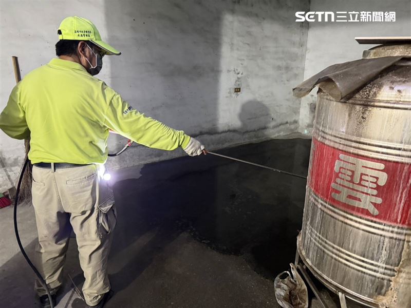 防疫人員針對戶內積水處進行水噴。(圖/高雄市衛生局提供)