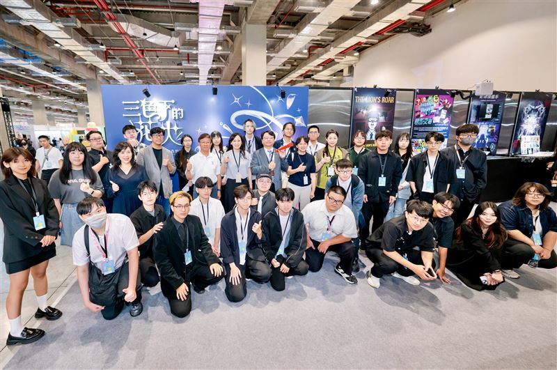 明新科大多媒體與遊戲發展系師生與董事張齊玲、校長呂明峯於新一代設計展展區合影留念,今年以「三色下的花火」作為策展概念,象徵新世代創作者在碰撞、交流與融合中逐漸形成屬於自己的創作語言。(圖/翻攝畫面)