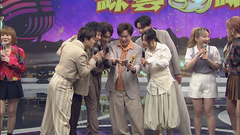 康康(中)手機裡有一張蔡小虎年輕時登台作秀的照片,令大夥驚呼「好日系喔」。(圖/中視提供)