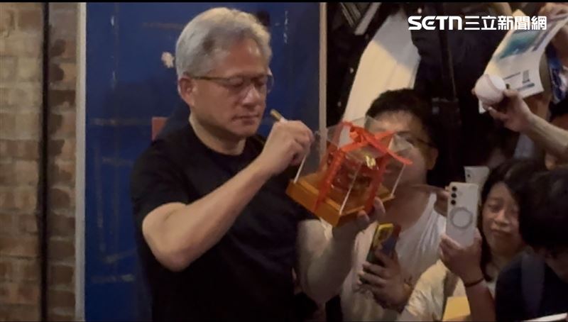 黃仁勳化身「寵粉魔人」,不論是自傳、棒球、手機殼,甚至有人拿出裝在透明盒中看似咬錢虎的公仔請他簽名,他都耐心逐一簽名,期間還大方掏出1000元送給粉絲,讓現場氣氛嗨到最高點。(圖/記者王文承攝影)