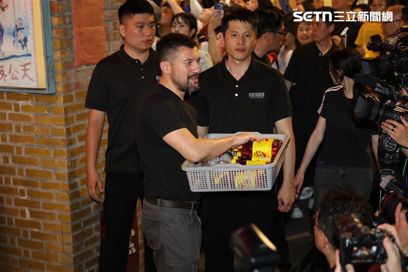 黃仁勳女兒黃敏珊，也親自提著一籃餐盒加入「投食」行列；兒子黃勝斌則與輝達產品經理一同協助發放飲料，展現一家人的親和力。（圖／記者鄭孟晃攝影）