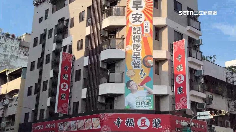 參選人將看板掛在豆漿店外，用日常問候拉近與選民的距離