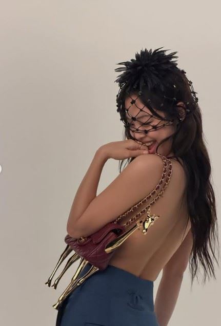 Jennie其中一組造型最受矚目，她上半身未穿外衣，以香奈兒2026 M&eacute;tiers d&rsquo;Art工坊系列長頸鹿造型酒紅色包款作為視覺遮擋重點，呈現大膽卻極具時尚張力的構圖，展現品牌與個人風格融合的強烈視覺效果。（圖／翻攝自Jennie IG）