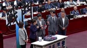 民眾黨團送蔣萬安戰鬥陀螺，結果遞過去時掉在地上（圖／翻攝畫面）