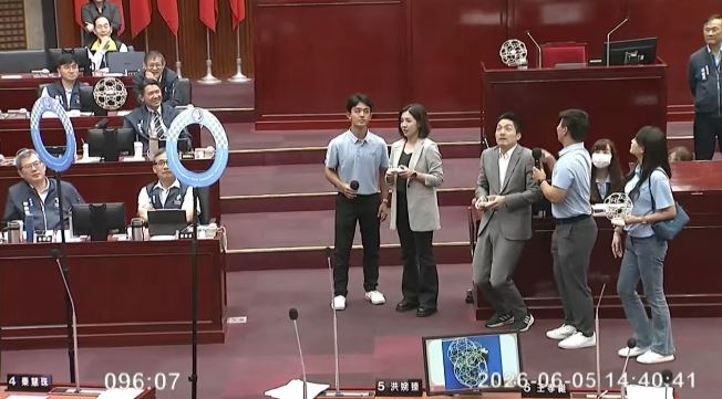 蔣萬安在台北市議會挑戰無人機足球，還半蹲躲球（圖／翻攝畫面）
