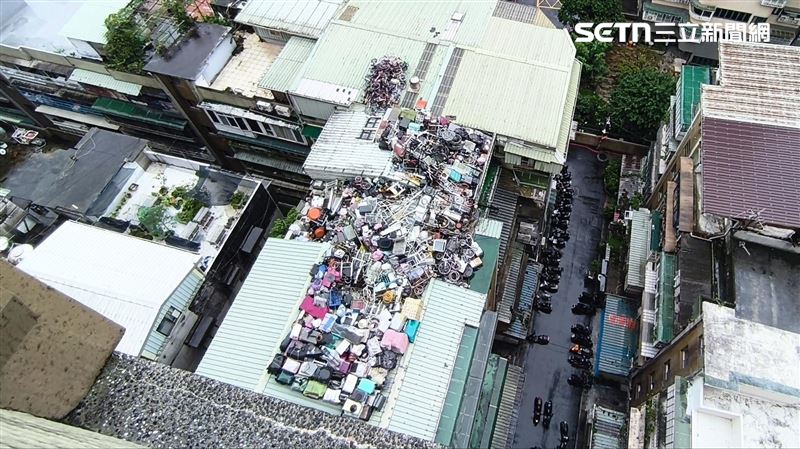 新莊8旬老翁在頂樓將雜物堆積如山，甚至鄰居的遮雨棚也堆好堆滿，隨時有崩落危險，在地里長感嘆，「已出動志工幫忙清運過一次了，80多人、花10小時，大家都老了，實在沒體力再來一次。」（圖／記者陳韋帆攝影）