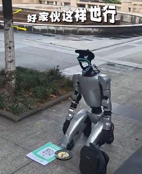 中製人形機器人在街上下跪乞討,不僅有QRCODE收款碼還有一個裝零錢的盤子。(圖/翻攝自@ruswar12458)