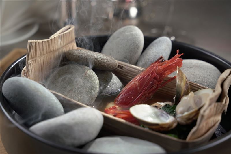 礁溪了了的晚餐可品味慢食三星融合原民美學的Tasting Menu,圖為月桃葉鹽封下的鮮甜海魚、熱石與檳榔葉鞘激盪出的鮮美魚湯。(圖/飯店旅宿業者提供)